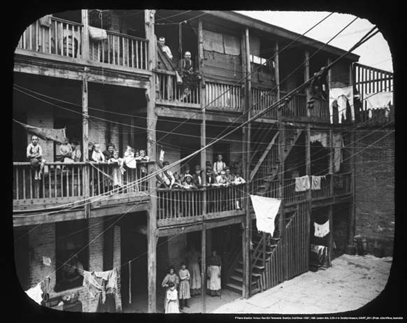 A photo from the 1920s shows a cramped and crowded multi-family boarding house
