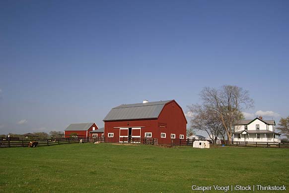 A modern photo shows a family farm with a red barn and a white farm house